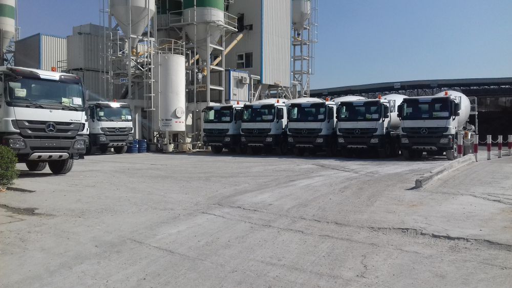 Modern Mix ready-mix concrete mixer trucks lined up beside the batching plant in Al Quoz, Dubai